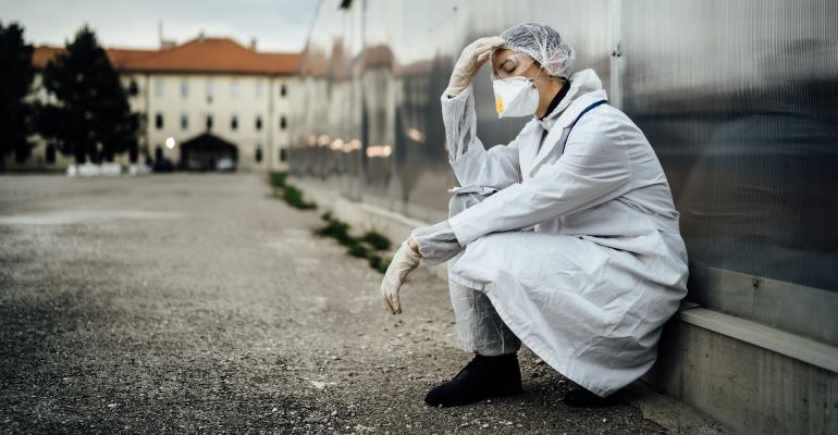 healthcare-worker-in-mask-slumped-outdoors-with-sad-expression.jpg